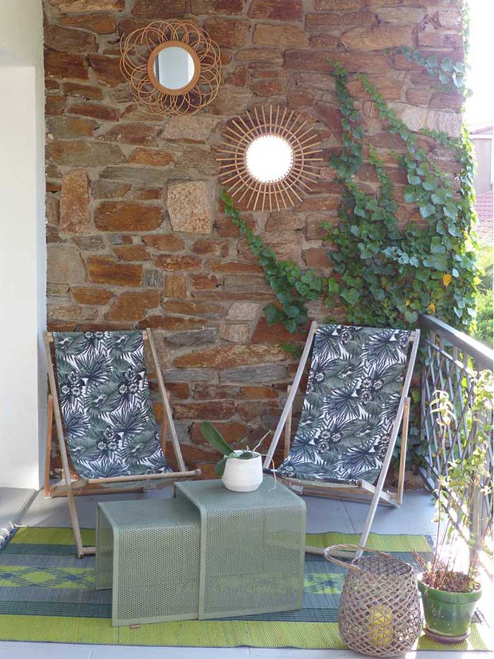 Coin détente avec chaises longues et mur en pierre naturelle