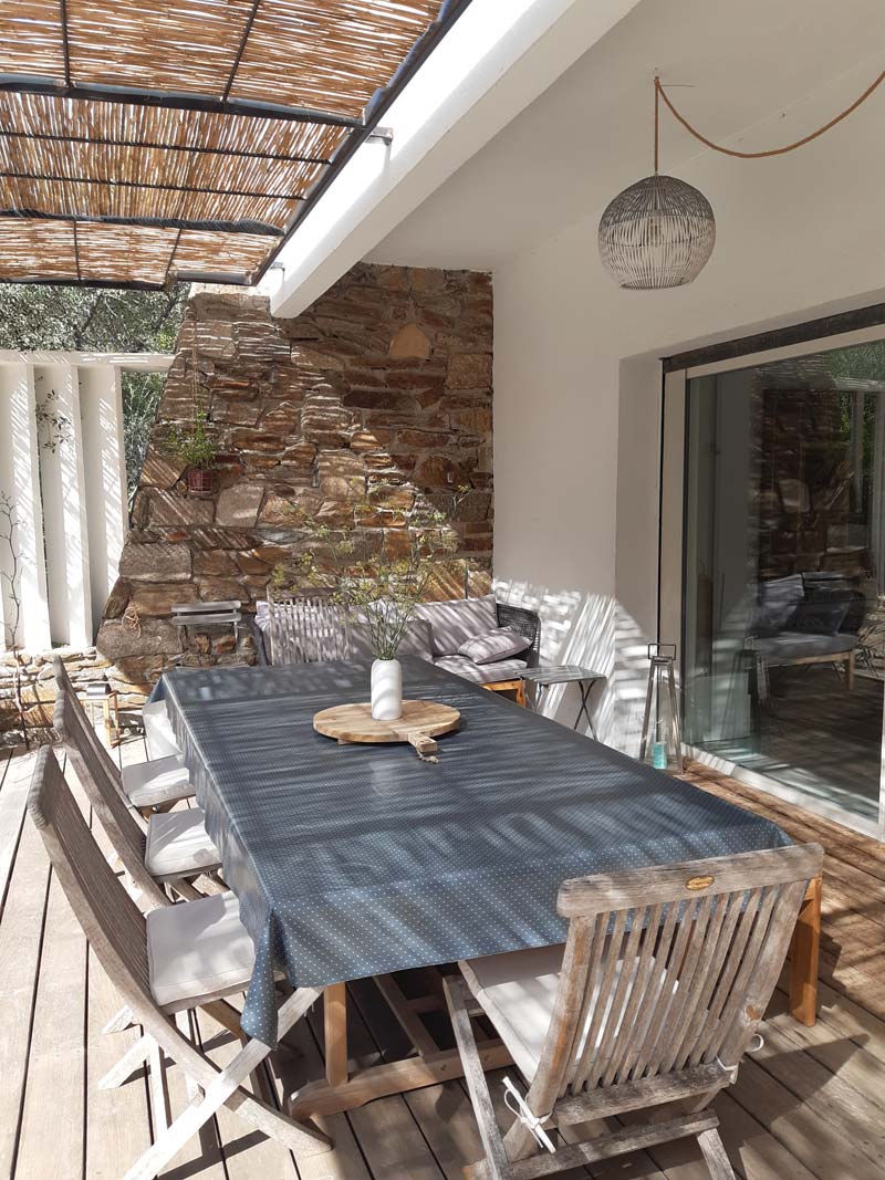 Table de repas en bois sous la pergola dans un jardin méditerranéen