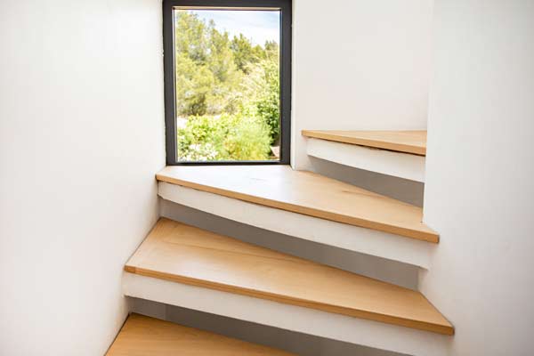 Détail de l'escalier avec marche en bois et fenêtre