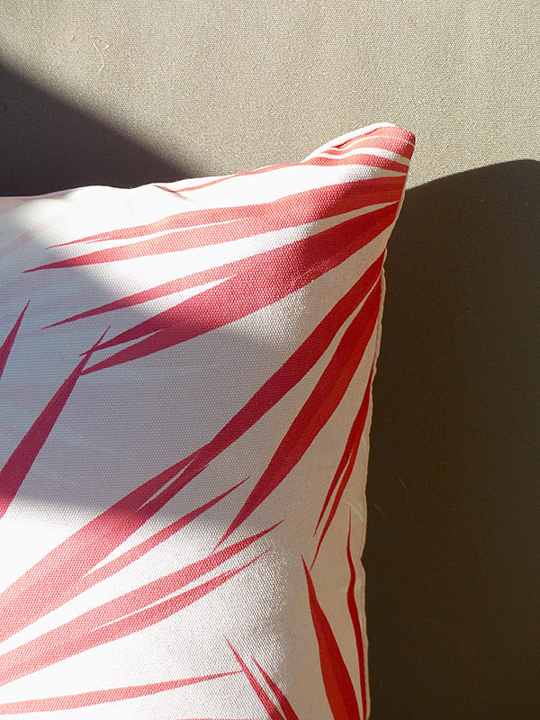 Détail déco textile outdoor – Réalisation Caroline Rey, designer d’espace à La Crau (Var) Coussin graphique rouge et blanc sur banquette extérieure
