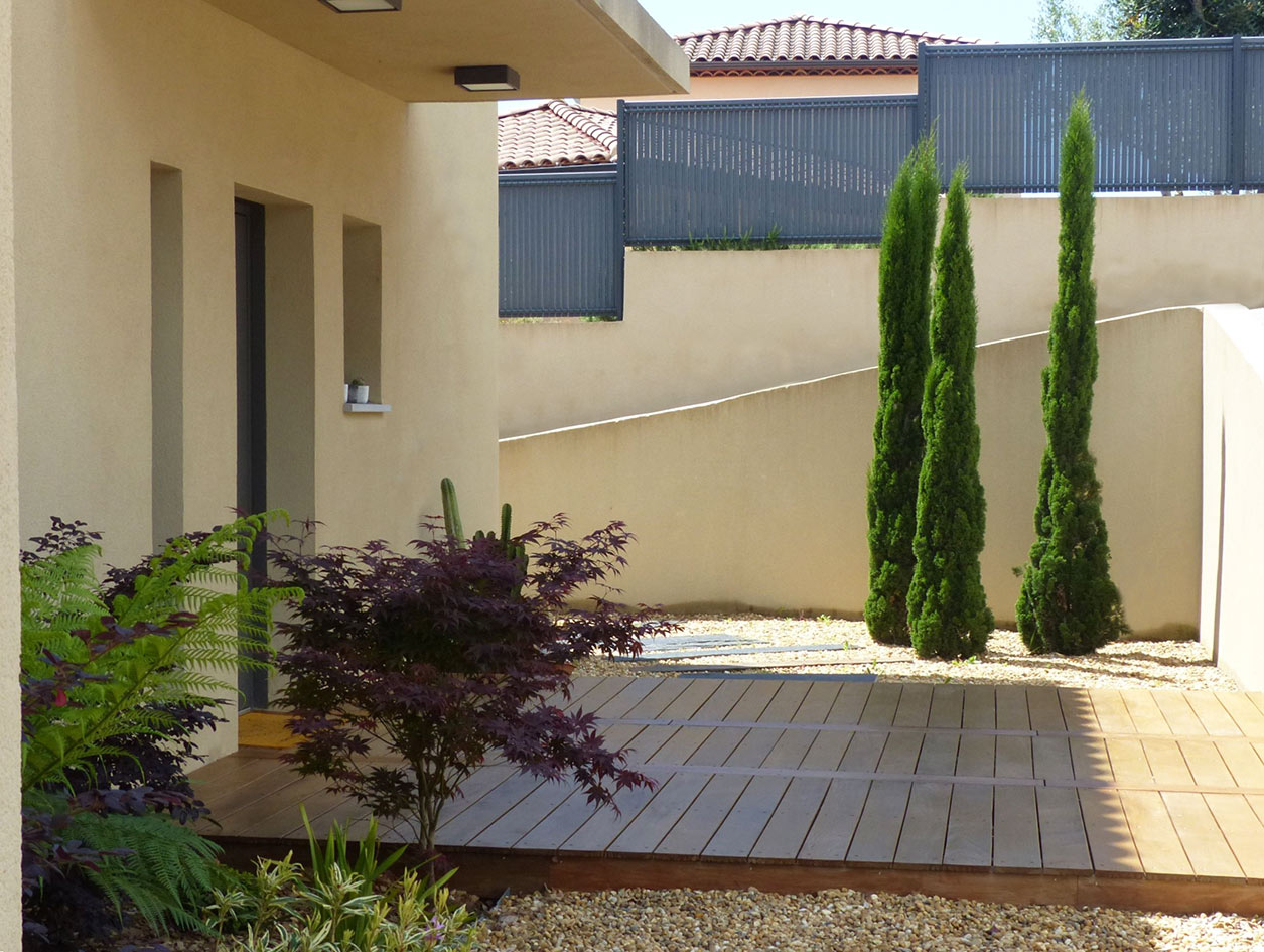 Entrée paysagée – Réalisation Caroline Rey, architecte d’extérieur à La Crau (Var) Entrée de villa contemporaine avec terrasse bois et cyprès
