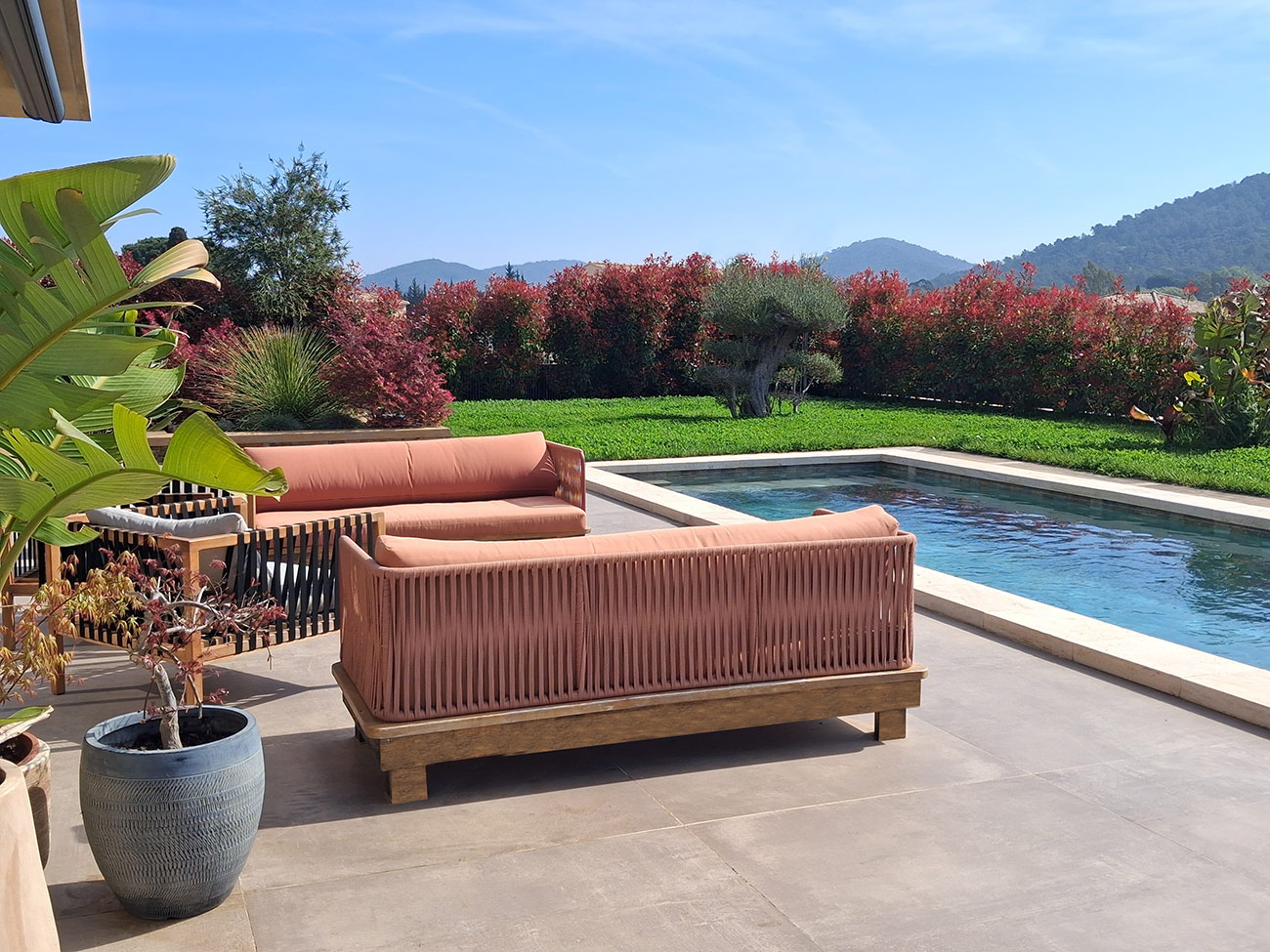 Terrasse autour de la piscine – Caroline Rey, architecte d’extérieur à La Crau (Var) Salon de jardin terracotta au bord d’une piscine avec végétation