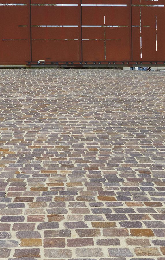 Allée carrossable en pavés – Réalisation Caroline Rey, architecte d’extérieur à La Crau (Var) Pavage en pierre naturelle devant un portail acier corten